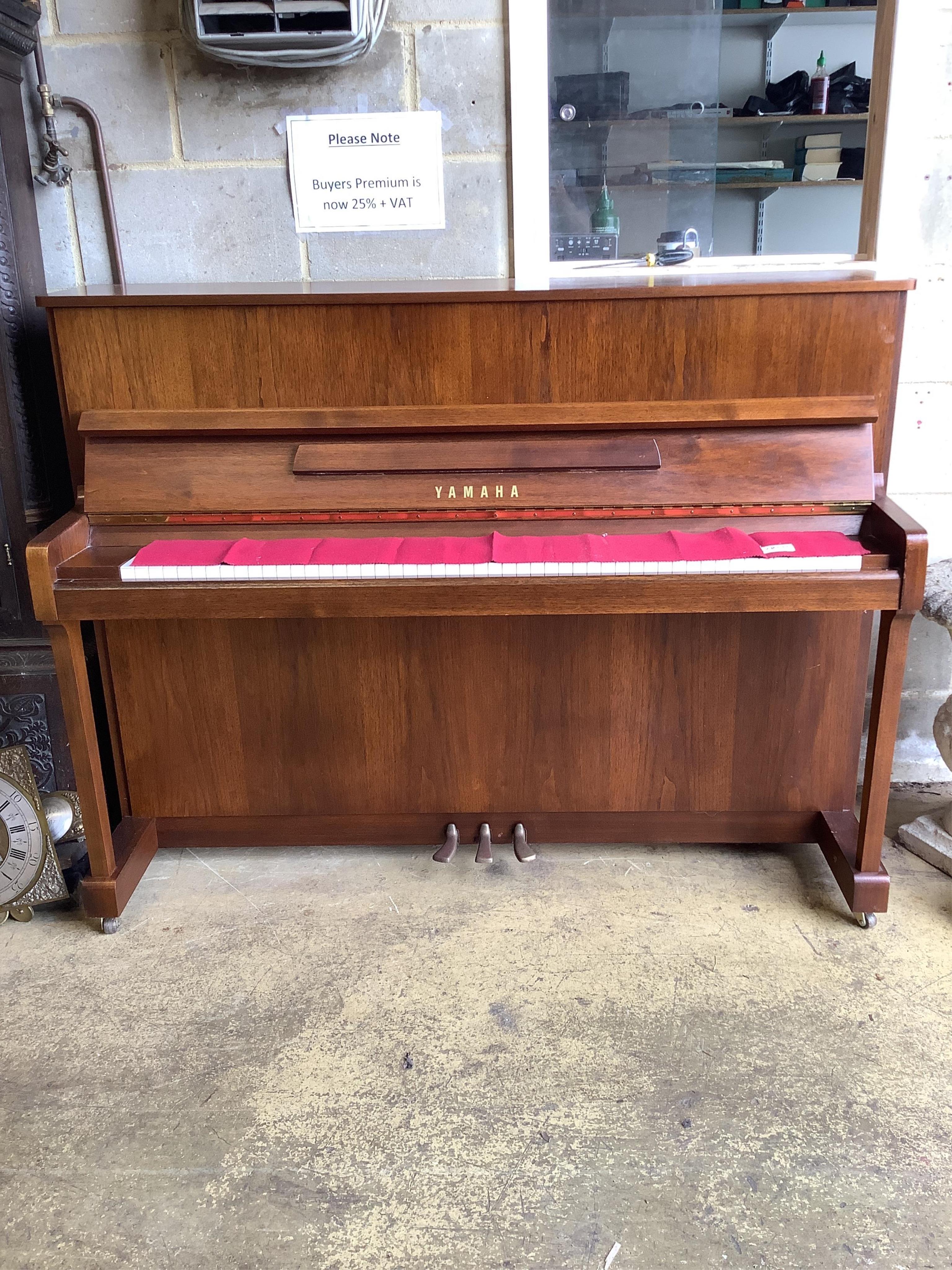 A Yamaha upright piano, model P116N, serial no.E252968, with its original sales booklet and an adjustable piano stool. Condition - good, in very good lightly used condition